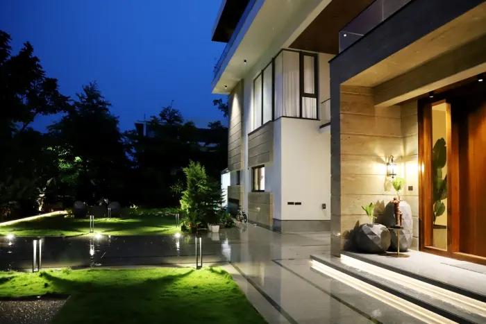 Pathway lights across a lawn leading to a lit home entry