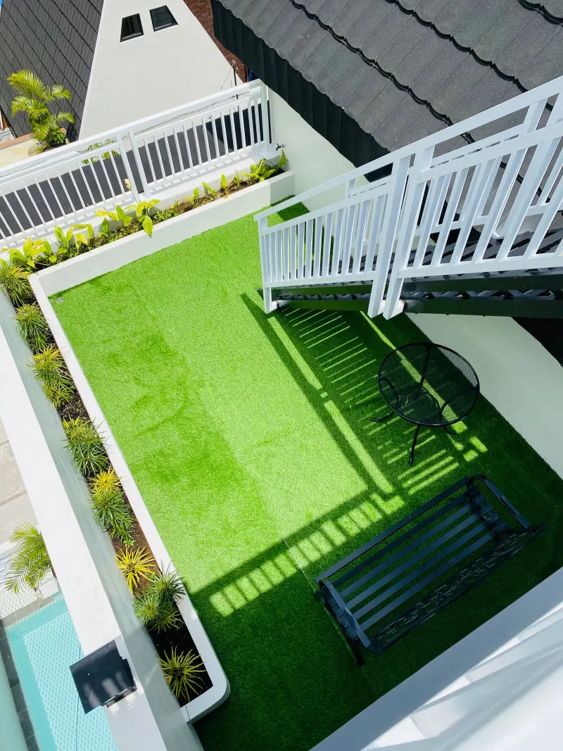 Installed turf area bordered by planting beds and a patio